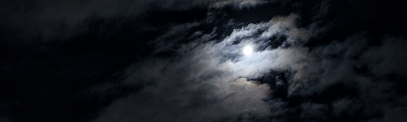 Night sky with moon and mystic clouds, panoramic scary dark gothic background. Concept of horror, Halloween, spooky space