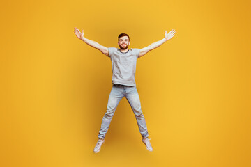 Energetic Man Jumping With Arms Outstretched