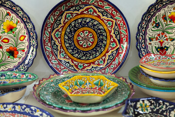 Traditional ceramics of Central Asia. Ancient traditional Uzbek ceramic dishes with national ornaments. Colorful handmade ceramics from Uzbekistan.