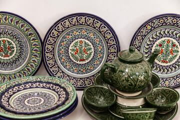 Traditional ceramics of Central Asia. Ancient traditional Uzbek ceramic dishes with national ornaments. Colorful handmade ceramics from Uzbekistan. - obrazy, fototapety, plakaty