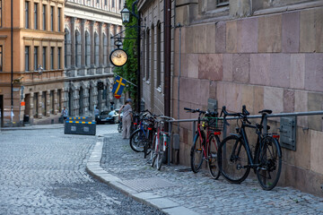 Traditional colorful building, paved street, parked bike in Stockholm, Gamla Stan Old Town, Sweden.