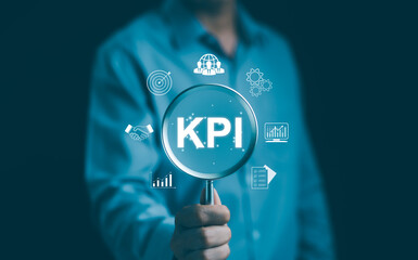 Businessman analyzing key performance indicators (KPI). Business executive holding a magnifying...