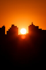 Pôr do Sol entre prédios da cidade