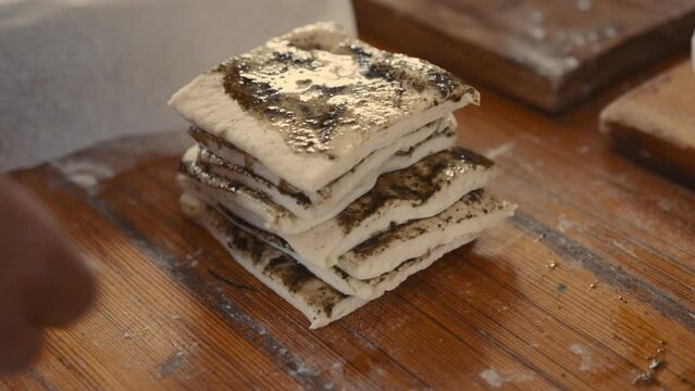 Baker stacking seasoned bread-dough strips