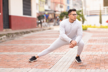lifestyle: young man does leg stretch to start his workout routine