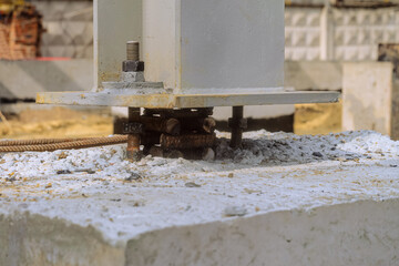 The base of a mounted metal column exposed at the design elevation on a concrete grillage before...