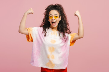 Portrait of beautiful smiling girl, teenager wearing t shirt rejoicing isolated on pink background