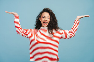 Portrait of positive attractive girl, teenager looking at camera making winner gesture isolated