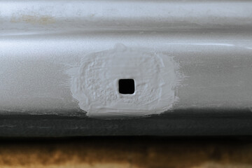 Part of a damaged car body with an epoxy primer protective coating applied. Car sill close-up.
