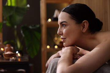 Spa therapy. Beautiful young woman lying on massage table in salon, space for text
