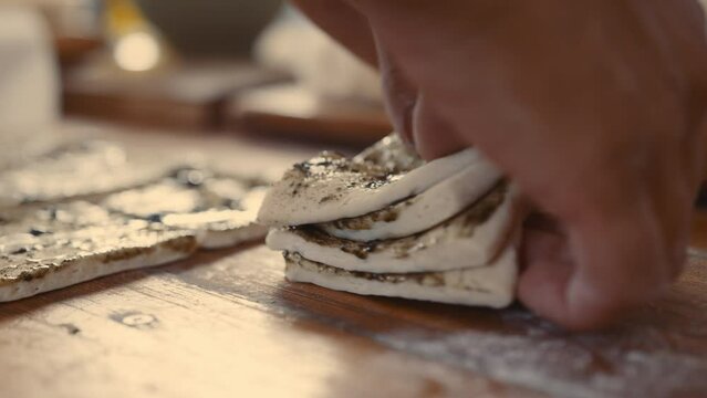 Baker stacking strips of seasoned dough