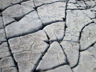 close up detailed shot of grey cracked rock formations on a beach in Somerset England