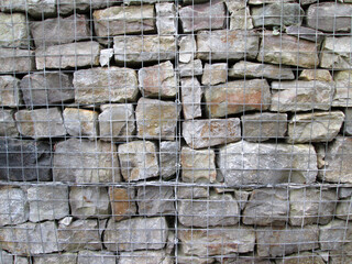 Grey stone blocks in a gambion wall construction 