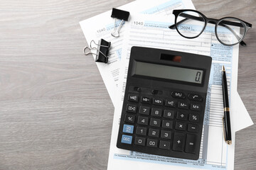 Tax accounting. Calculator, documents, glasses and stationery on wooden table, flat lay