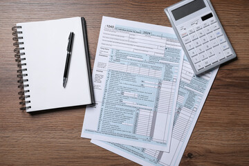Payroll. Tax return forms, calculator, notebook and pen on wooden table, flat lay