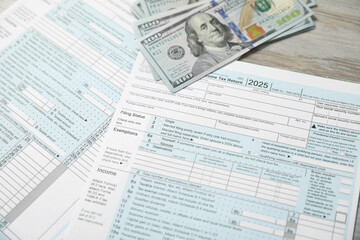Payroll. Tax return forms and dollar banknotes on wooden table