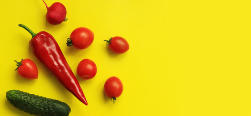 Red pepper, tomatoes, radish and cucumber on a yellow background. Hot red pepper and vegetables for...