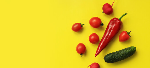 Red pepper, tomatoes, radish and cucumber on a yellow background. Hot red pepper and vegetables for...