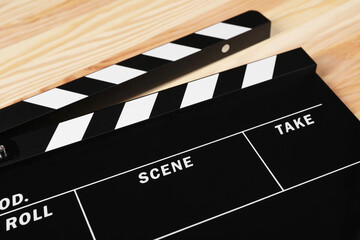 One clapperboard on wooden table, closeup view
