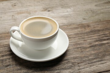 Aromatic coffee in cup on wooden table. Space for text