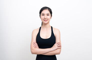 Attractive Asian woman in black workout clothes doing arm stretching on white background. Confident young female athlete body warm up before workout on isolated.