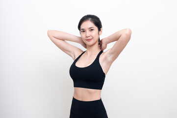 Fototapeta na wymiar Attractive Asian woman in black workout clothes doing arm stretching on white background. Confident young female athlete body warm up before workout on isolated.