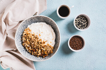 Bowl with yogurt, muesli and nuts for a healthy breakfast on the table top view