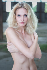 Portrait of Beautiful Nude Young Blond Adult Girl in the Abandoned Building. Curious, Sad Face. Portrait. Blue Eyes
