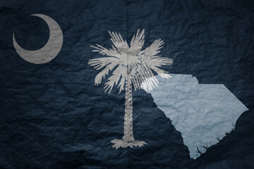 big national flag and map of south carolina state on a grunge old paper texture background