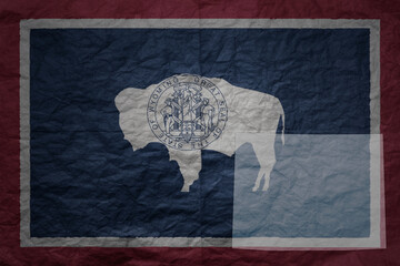 big national flag and map of wyoming state on a grunge old paper texture background