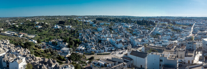  Aerial drone view of Beautiful stone Trulli houses with narrow streets in village of Alberobello....
