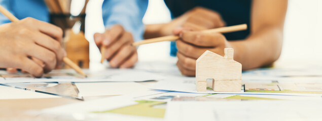 A portrait of professional architect team discussion about architectural project on meeting table...