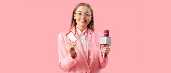 Female journalist with microphone on pink background