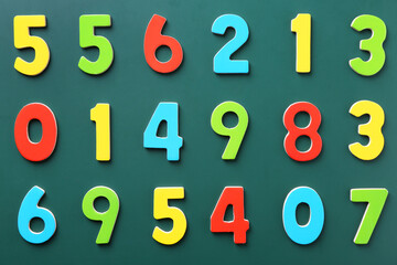 Colorful numbers on green background, flat lay