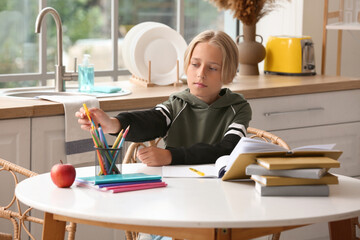 Little boy doing homework in kitchen