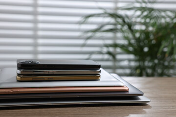 Many different modern gadgets on wooden table indoors. Space for text