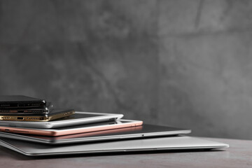 Many different modern gadgets on grey table, closeup. Space for text