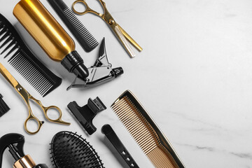 Hairdressing tools on white marble table, flat lay. Space for text