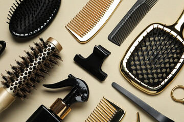 Different hairdresser tools on beige background, flat lay