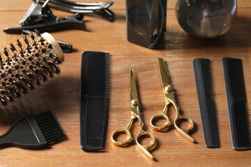 Hairdresser tools. Different scissors and combs on wooden table