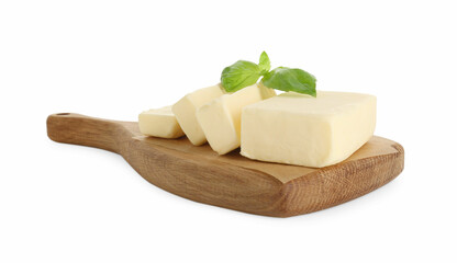 Board with tasty cut butter and basil isolated on white