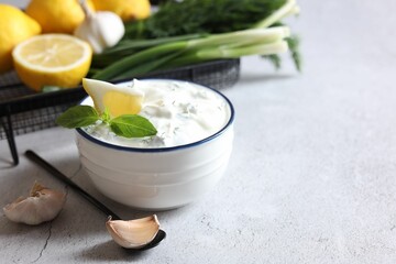 Delicious yogurt and ingredients on light textured table, space for text