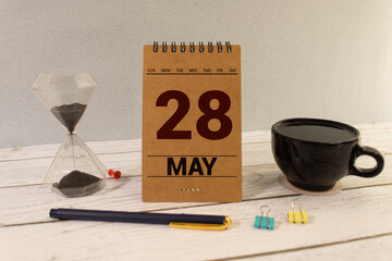 Close up of a wooden perpetual calendar showing the 28th of May. Shot close
