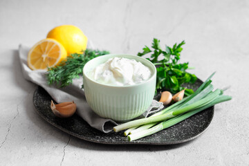 Delicious yogurt in bowl and ingredients on light textured table