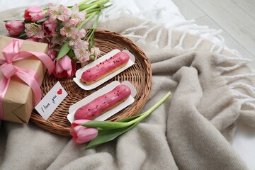 Tasty breakfast served in bed. Delicious eclairs, tea, flowers, gift box and card with phrase I...