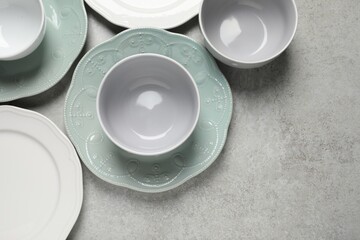 Beautiful ceramic dishware on light grey table, flat lay. Space for text