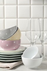 Beautiful ceramic dishware and glasses on light grey table
