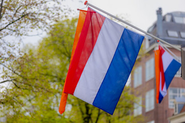 Netherlands flag with horizontal tricolour of red, white and blue, Orange flag hanging outside...