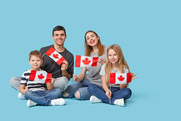 Happy family with flags of Canada sitting on blue background