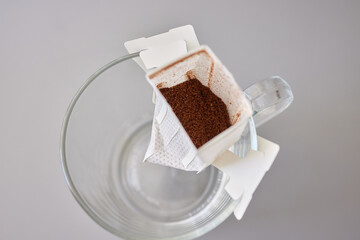 brewing process,a bag filled with boiling water for drip coffee in a cup,top view.